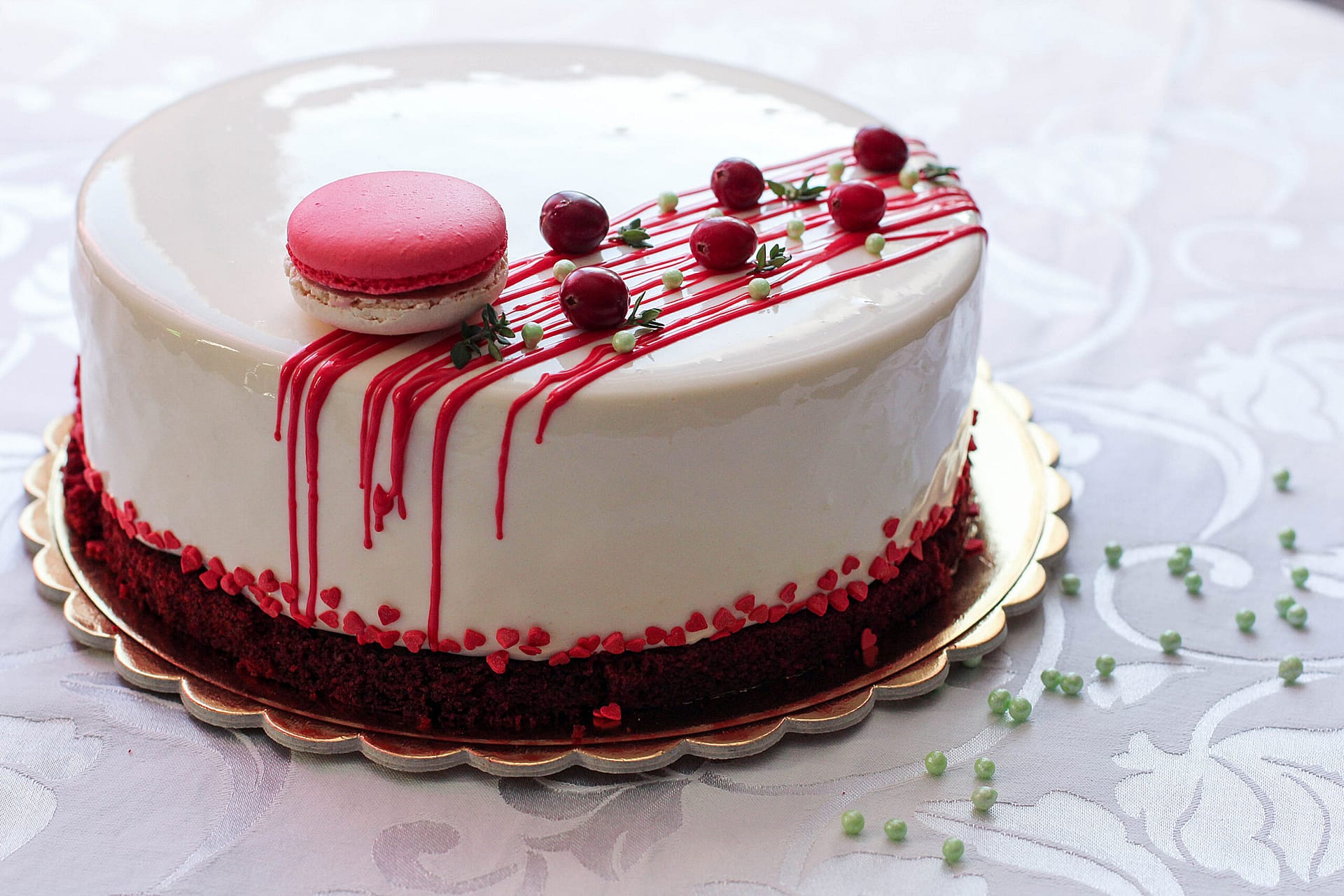 Tasty white homemade cake decorated by red berries and macaron